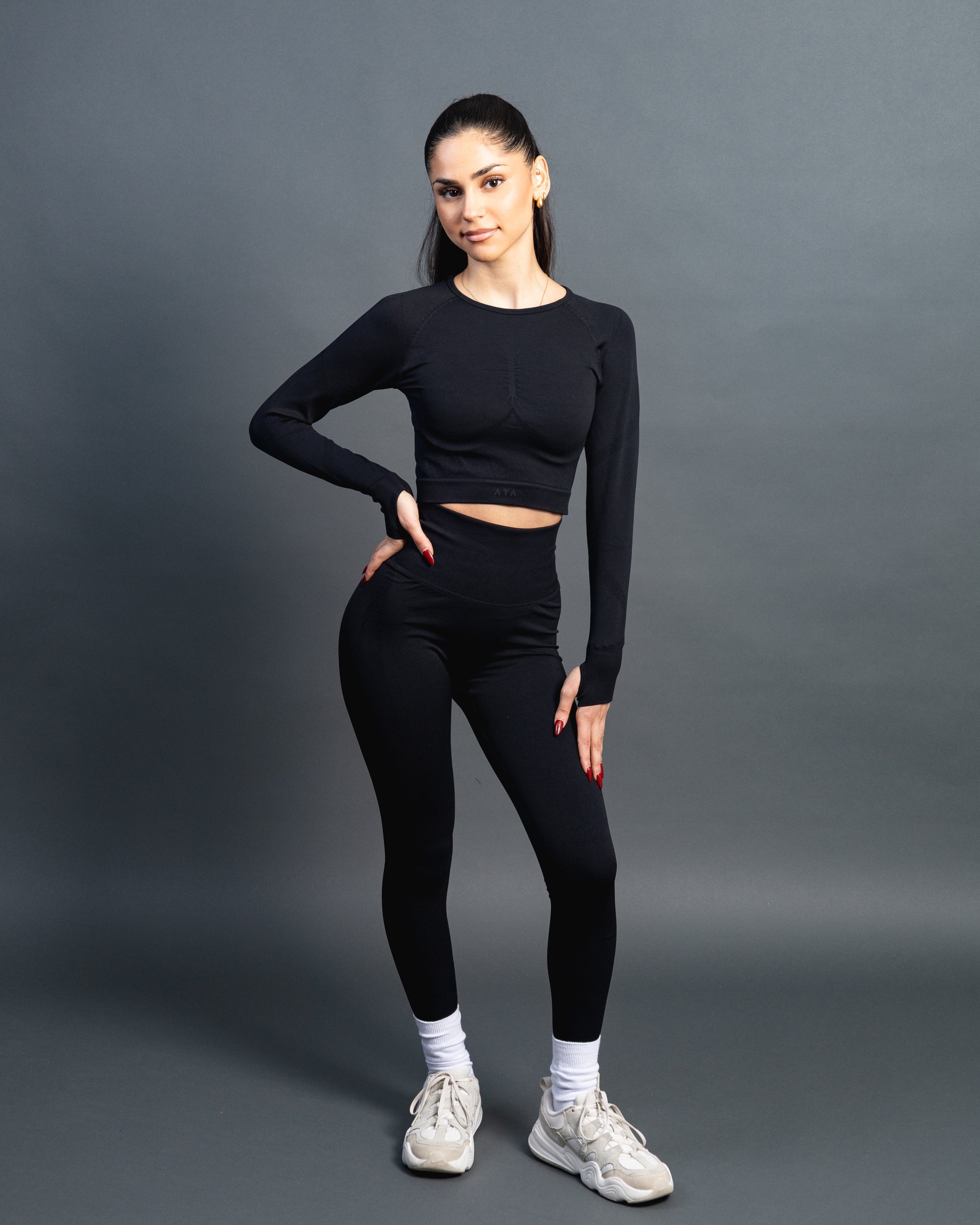 Woman wearing black high-waisted seamless leggings and sports bralette – figure-hugging push-up leggings for gym and everyday wear